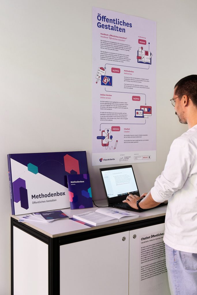 Eine Person steht in der CityLAB Ausstellung vor einem Laptop und benutzt den Chatbot Öffentliches Gestalten
