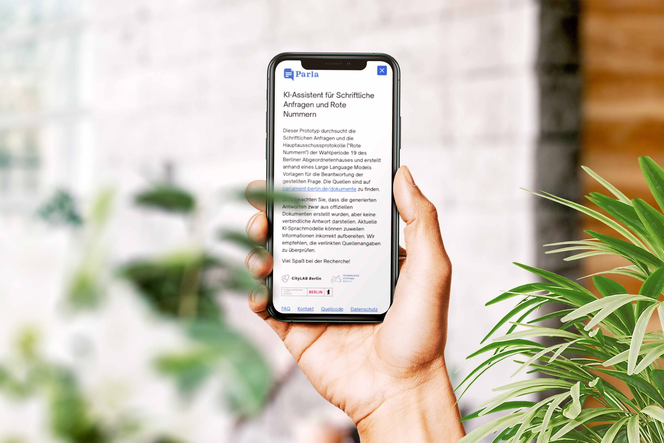 Auf dem Mock-up ist eine Hand zu sehen, die ein Smartphone hält. Auf dem Bildschirm sieht man die Anwendung "Parla" vom CityLAB Berlin.